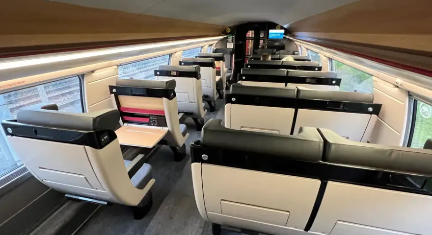 Interior of a modern train carriage, likely the Paris to Bilbao train, with rows of comfortable, beige and black seats.