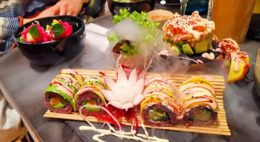 Köstliches vegetarisches Sushi mit Avocado und bunten Gemüsesorten, serviert mit Rauch-Effekt. Ein Genuss für Augen und Gaumen in diesem **restaurant vegetarisch**.