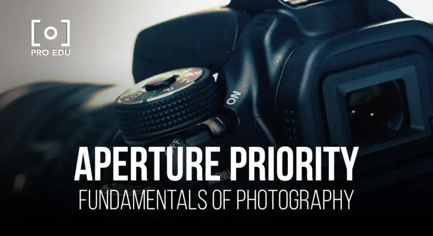 Gros plan sur un appareil photo, avec le texte "APERTURE PRIORITY" et "FUNDAMENTALS OF PHOTOGRAPHY". Le mode priorité ouverture est essentiel pour maîtriser la profondeur de champ.