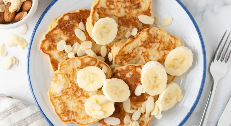 Deliciosas tortitas de plátano, cubiertas con rodajas de plátano y almendras laminadas. Un desayuno perfecto.