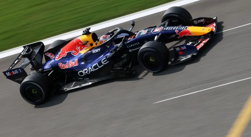 Coche de Red Bull Racing en plena carrera, con el logo del toro rojo y patrocinadores visibles.
