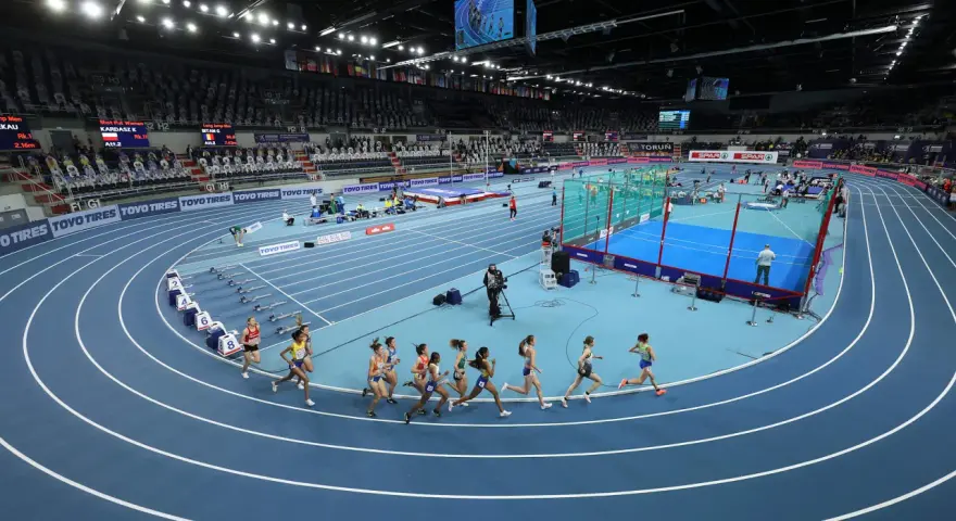 Carrera de atletismo hoy, horario de competición en pista cubierta. Atletas compiten en la pista azul.
