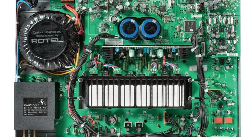Wnętrze wzmacniacza Rotel A14 MKII z dużym transformatorem i zieloną płytką drukowaną.