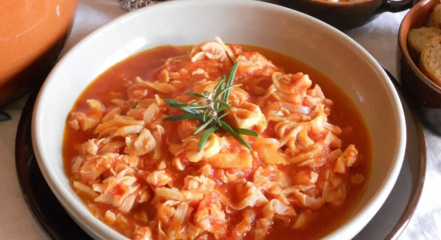 Trippa ricetta della nonna in un piatto bianco, guarnita con rosmarino. Un classico sapore di casa.