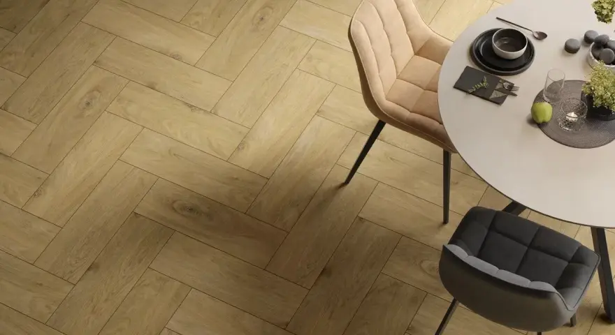 Eleganckie wnętrze z podłogą w jodełkę. Okrągły stół z krzesłami, nakryty do posiłku.
