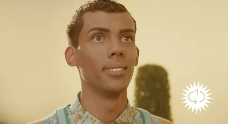 Ein Mann mit lockigem Haar und einem bunten Hemd blickt nach oben. Das Bild erinnert an die Bedeutung von "Papaoutai".