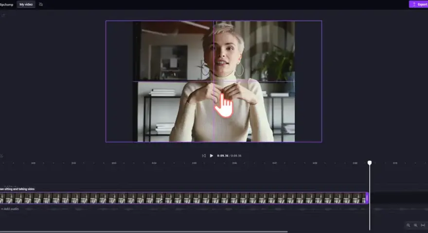 Kobieta w białym golfie, siedząca i mówiąca, z dłonią wskazującą na ekran edytora wideo.