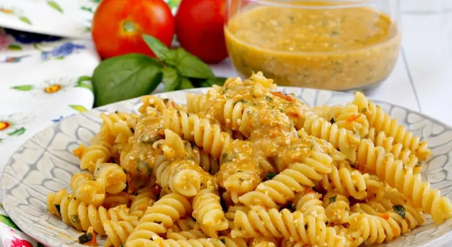 Fusilli conditi con una cremosa salsa di ricotta e pomodorini, guarniti con basilico fresco.