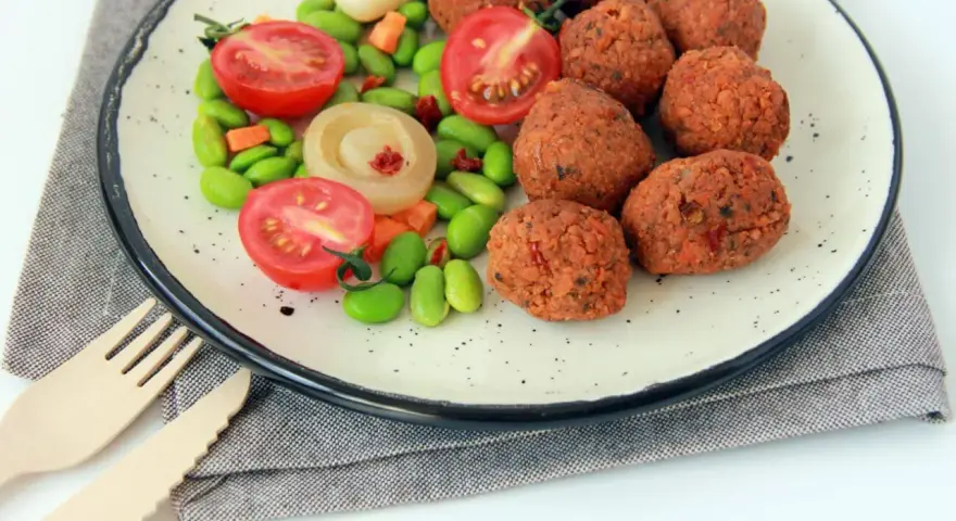 Falafel kontra kotlety sojowe: kulki z ciecierzycy i warzywa na talerzu.