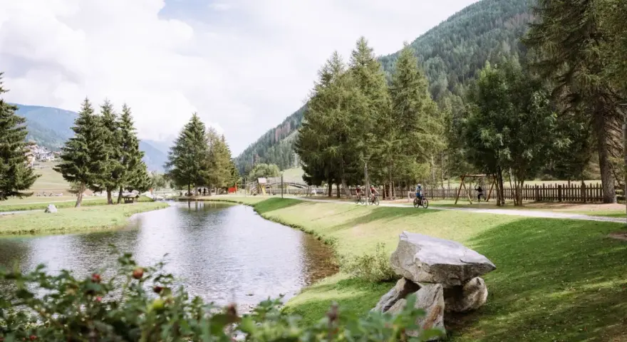 Passeggiata in bici ai laghetti di San Leonardo, tra alberi e montagne.