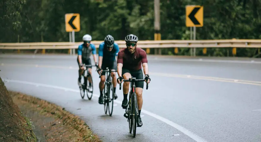 Cyclists on a wet road, navigating curves, embodying the stress recovery adaptation cycle.