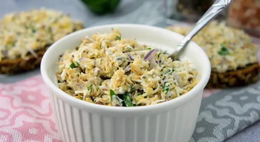 Pyszna pasta z makreli z cebulką i natką pietruszki, podana w białej miseczce, gotowa do smarowania.