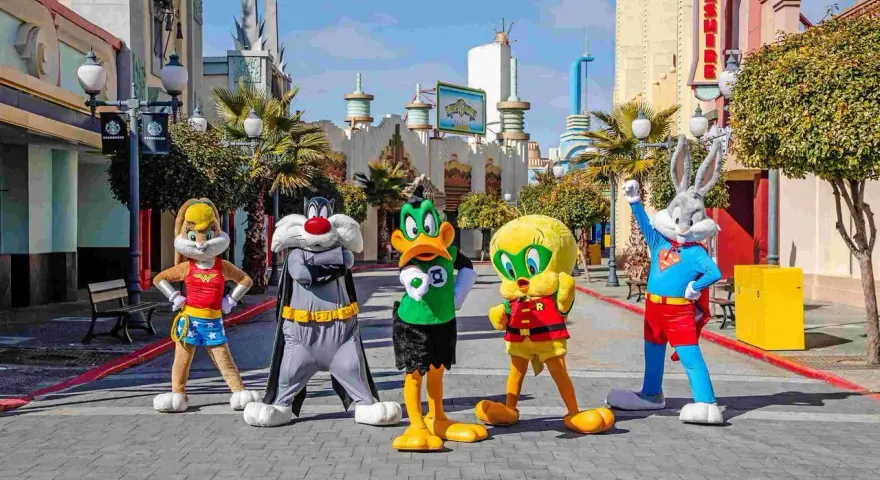 Personajes de Looney Tunes celebran la nueva atracción Warner. Bugs Bunny, Piolín, Silvestre, Lola Bunny y el Pato Lucas posan en la calle.
