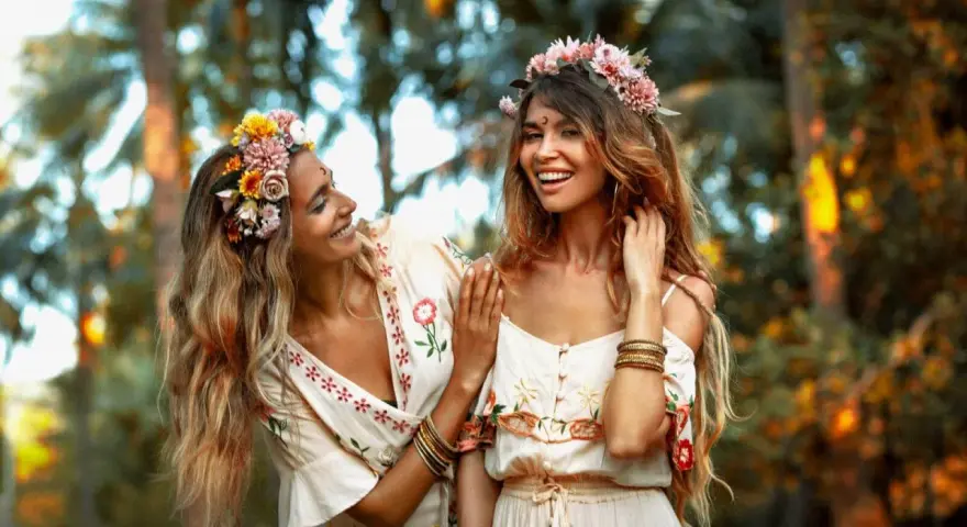 Dos amigas sonríen, adornadas con coronas de flores. Su vínculo es tan fuerte como una **piedra de la amistad**.