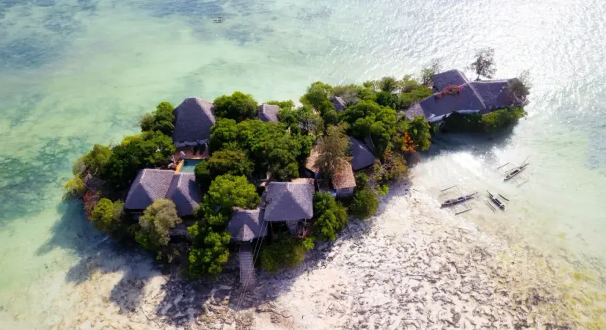 Rajska wyspa z chatkami i basenem, otoczona turkusową wodą. Idealne zanzibar atrakcje dla szukających spokoju.