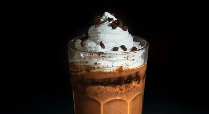 Eiskaffee selbst machen: Ein Glas mit cremigem Eiskaffee, Sahne und Schokostückchen. Perfekt für heiße Tage!