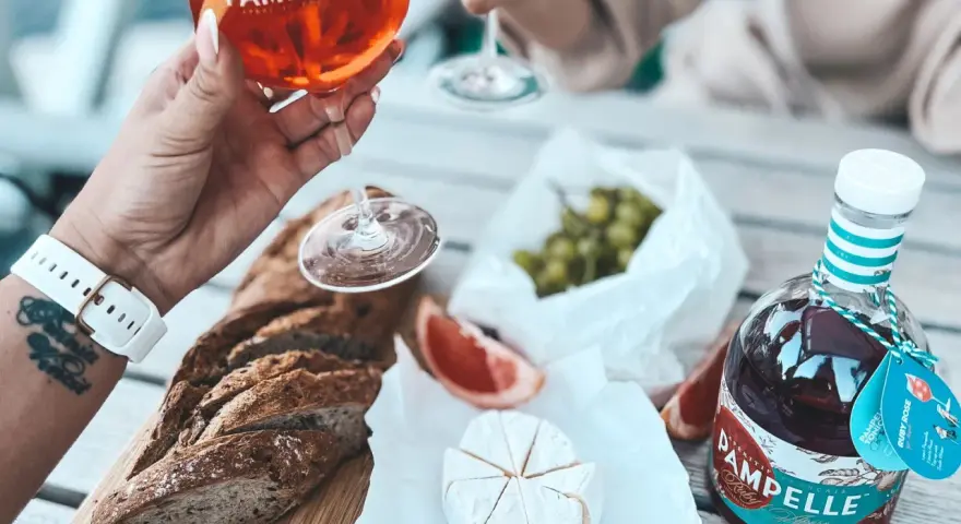 Aperitif co to? Kieliszek Pamplelle Ruby Rose, bagietka, ser brie i winogrona tworzą idealny zestaw na letnie popołudnie.