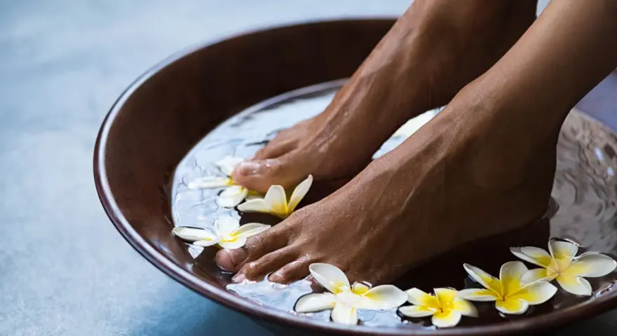 Relaxing foot bath with frangipani flowers. The amount of epsom salt in a foot bath can vary, but a common recommendation is 1/2 cup per gallon of water for a soothing soak.