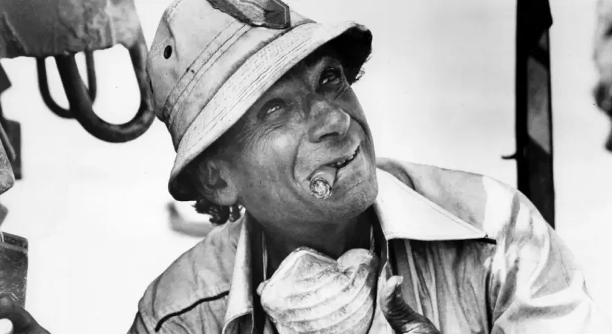 Un uomo con un sigaro in bocca e un cappello da esploratore, in un'immagine iconica di un film di Samuel Fuller.