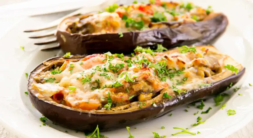 Berenjenas rellenas de carne picada, gratinadas con queso y perejil fresco. Un plato casero y delicioso.