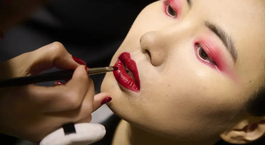 Labbra rosse intense e un trucco audace sugli occhi creano un look da sirena.