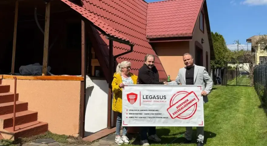 Trzy osoby trzymają baner "Budynek zalegalizowany", symbolizujący jak zrobić odbiór domu po 20 latach.