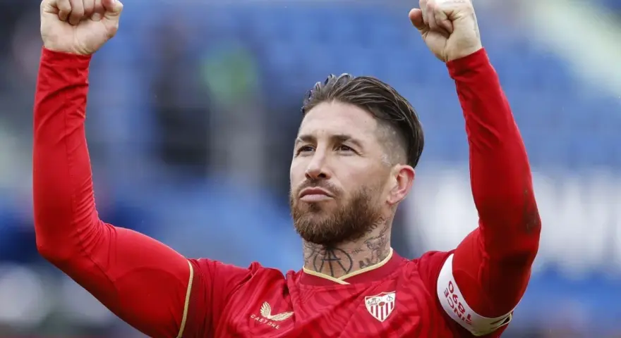 Sergio Ramos w czerwonej koszulce z podniesionymi pięściami, świętuje zwycięstwo. To właśnie tam, gdzie gra Sergio Ramos, czuć emocje!
