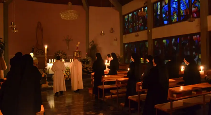 Schwestern in einem Gottesdienst, Kerzenlicht erhellt die Szene. Markus 16.