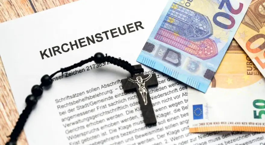 Kirchensteuer-Dokument mit Kreuz und Euro-Scheinen. Informationen zur Frage: Kirchenaustritt ab wann wirksam.