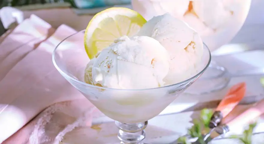 Erfrischendes Zitroneneis selber machen: Cremige Kugeln im Glas, garniert mit einer Zitronenscheibe. Perfekt für heiße Tage!