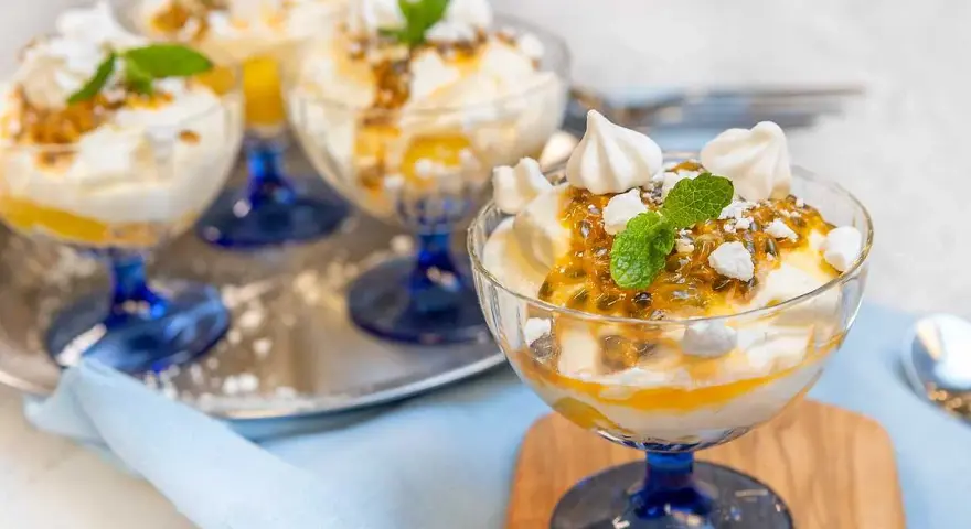 Fluffig Eton Mess med passionsfrukt och maräng i glasbägare. En härlig dessert som smälter i munnen.