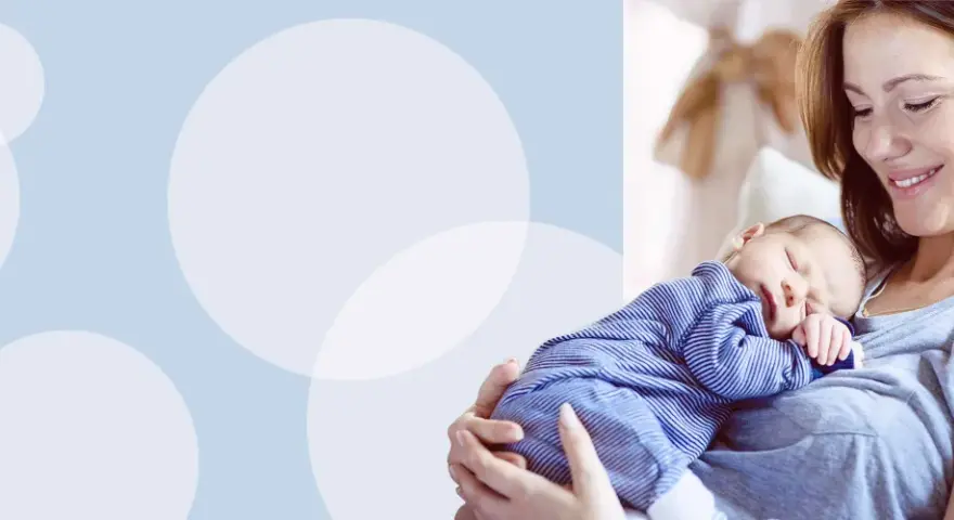 Uśmiechnięta mama tuli śpiącego noworodka w pasiastym pajacyku. Wskazówki, jak ubierać noworodka w domu.