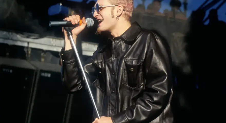 Layne Staley w skórzanej kurtce śpiewa do mikrofonu. Jego śmierć wciąż porusza fanów.