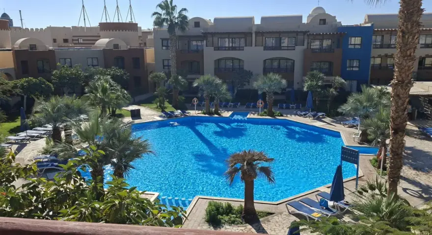 Basen w Radisson Individuals Marina Port Ghalib. Opinie gości chwalą ten tropikalny raj z palmami i krystalicznie czystą wodą.