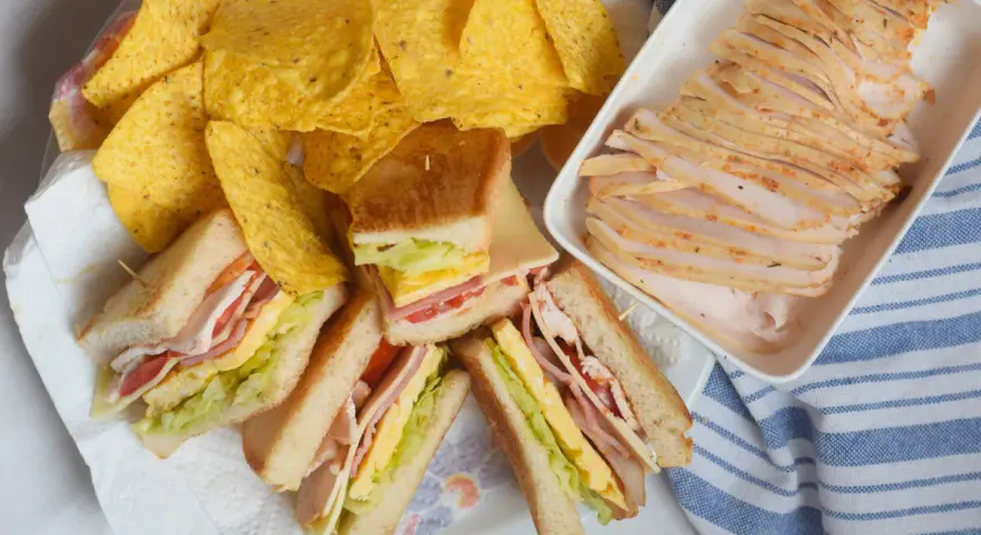 Sandwiches de fiambre de pollo casero, papas fritas y lonchas de pollo. ¡Un festín listo para disfrutar!