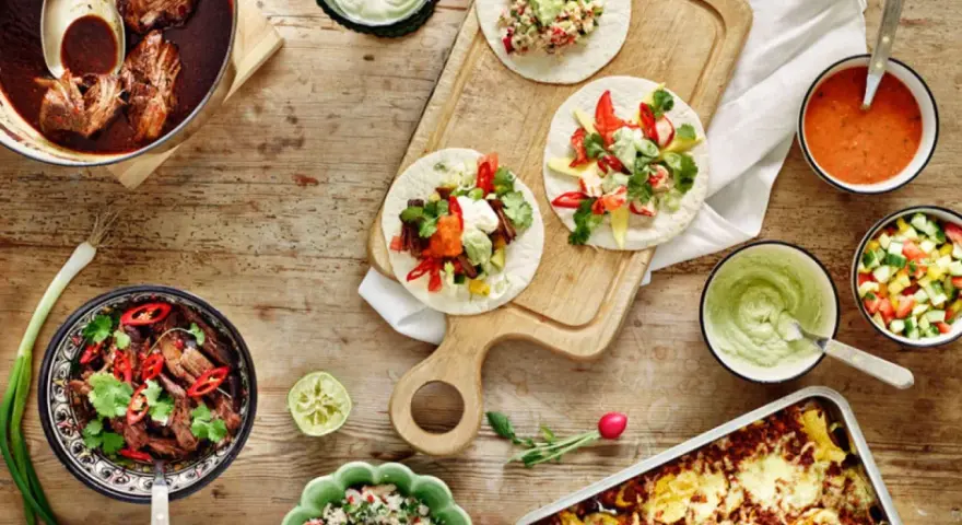 En härlig dukning med tacos, gryta med kött, salsa och guacamole. Perfekt för en mysig kväll med vin till tacos.