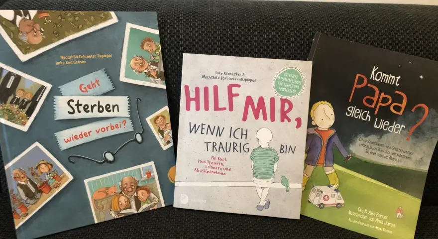 Drei Kinderbücher zum Thema Trauer und Verlust. Ein Kind sieht seinen verstorbenen Opa auf einem Bild.