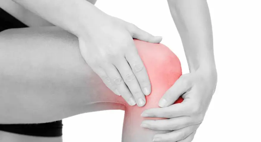 En person håller om ett knä som lyser rött, vilket indikerar smärta. Här sitter benhinnorna, som kan drabbas av inflammation.