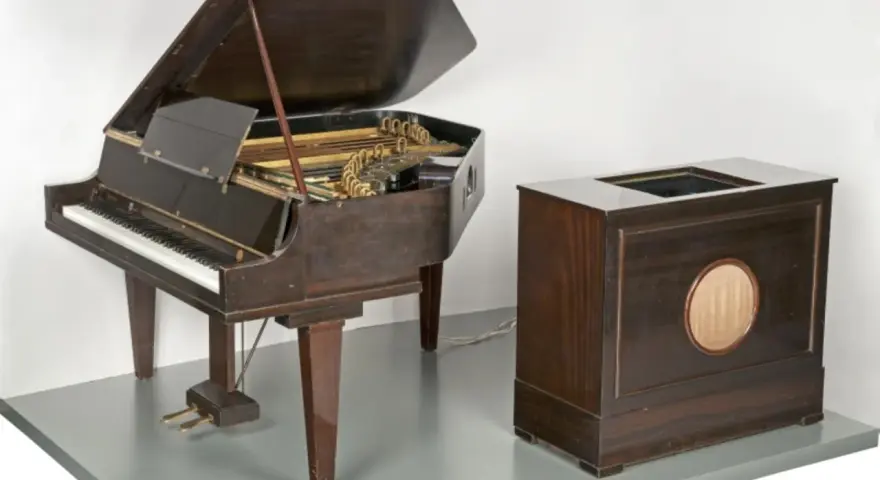 Ein Flügel und ein Holzgehäuse mit Lautsprecher, die zusammen den Beginn des Electronica-Genres markieren.
