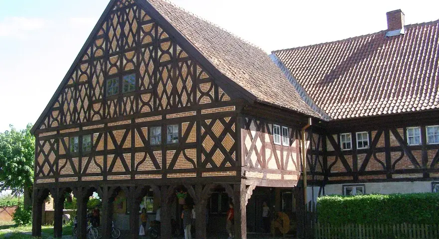 Piękny dom podcieniowy z charakterystyczną, zdobioną szachulcową fasadą i ceramicznym dachem.