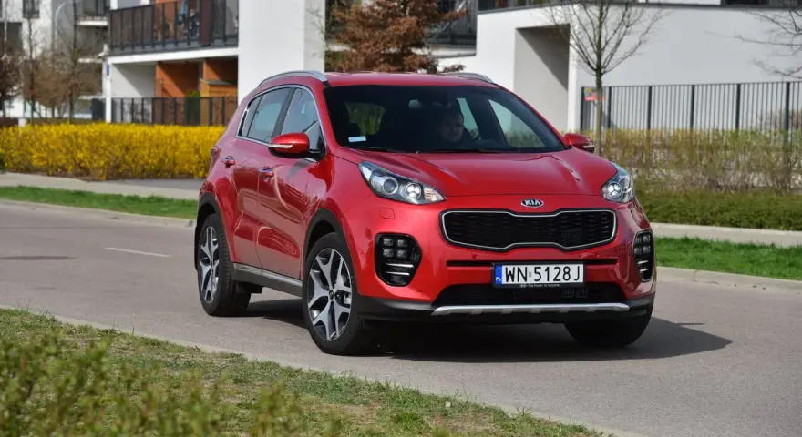 Czerwony Kia Sportage 4 na drodze, gotowy do wymiany żarówki.