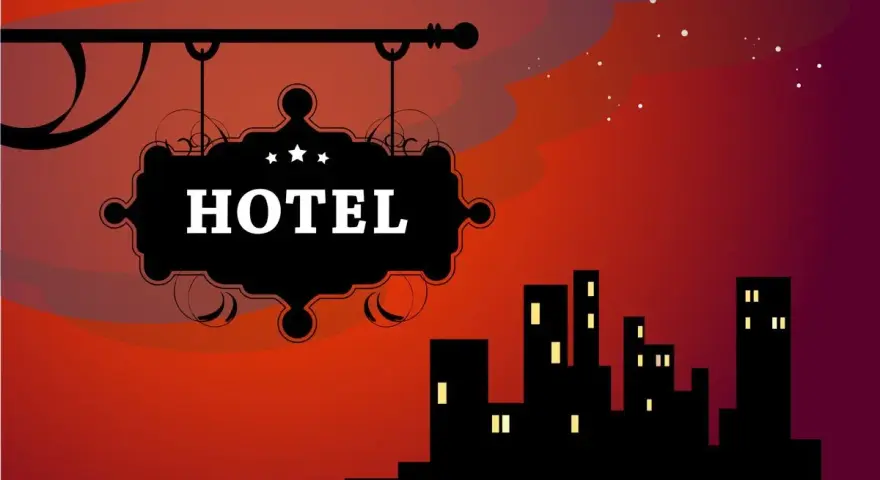 Czarny szyld hotelowy z napisem "HOTEL" na tle nocnego miasta i czerwonego nieba.
