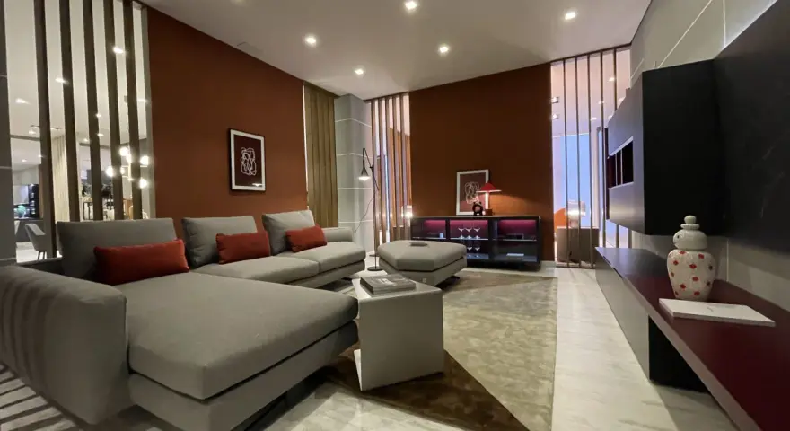Soggiorno moderno con pareti color terracotta e divano grigio. Effetti pittura pareti moderne che creano un'atmosfera calda e accogliente.