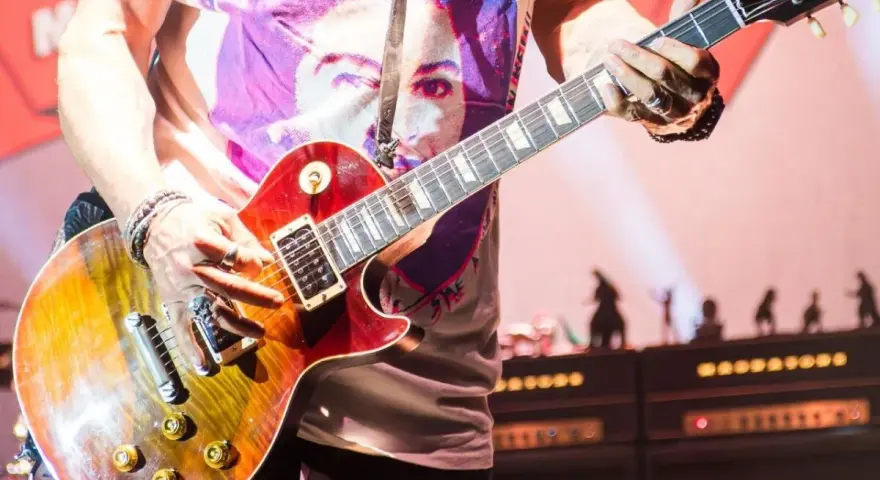 Muzyk gra na gitarze Gibson Les Paul, tworząc dźwięki, które mogłyby znaleźć się na najważniejszych płytach w historii muzyki.
