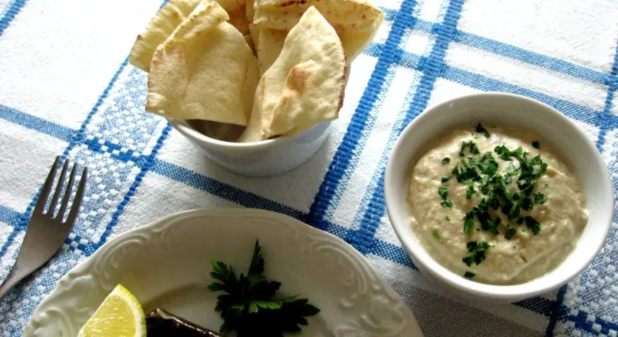 Pyszna pasta z bakłażana z natką pietruszki, podana z pitą i cytryną. Idealna na przekąskę.