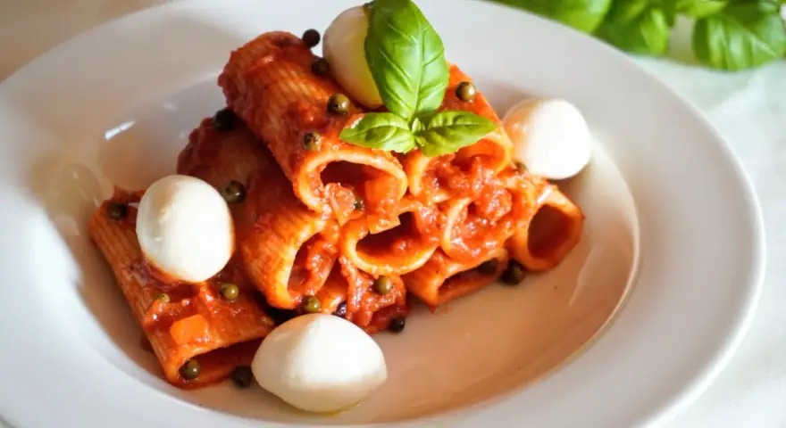Rigatoni z sosem pomidorowym, kulkami mozzarelli i bazylią. Szybki obiad z makaronem z czerwonym pesto ze słoika.