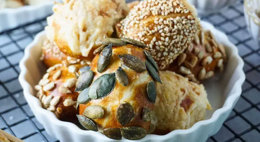 Köstliche laugen konfekt mit Kürbiskernen, Sonnenblumenkernen und Sesam in einer weißen Schale.