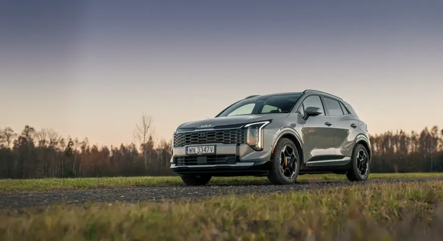 Nowy Kia Sportage hybryda na tle jesiennego krajobrazu. Elegancki SUV z nowoczesnym designem.