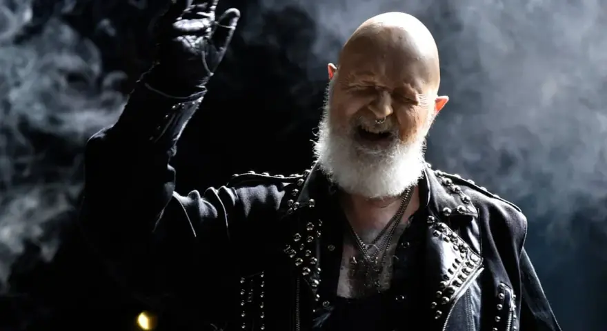 Rob Halford, der offen schwul ist, rockt die Bühne in Lederjacke und mit Bart.