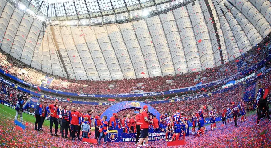 Piłkarze świętują zdobycie STS Pucharu Polski na murawie stadionu, zasypani czerwonymi konfetti.